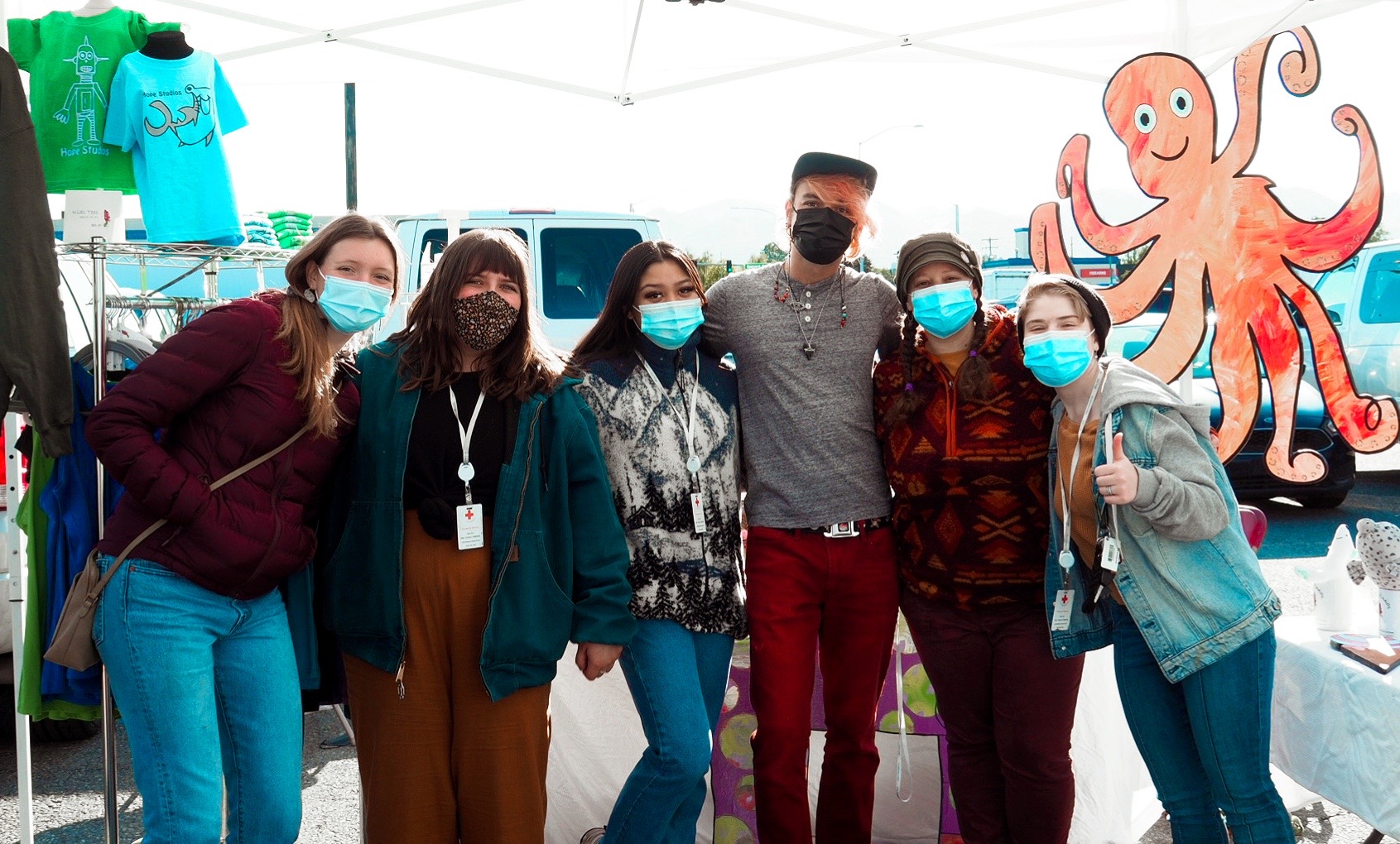 Six members of Hope's Community Engagement team stand with their arms around each other and wear COVID-19 face masks