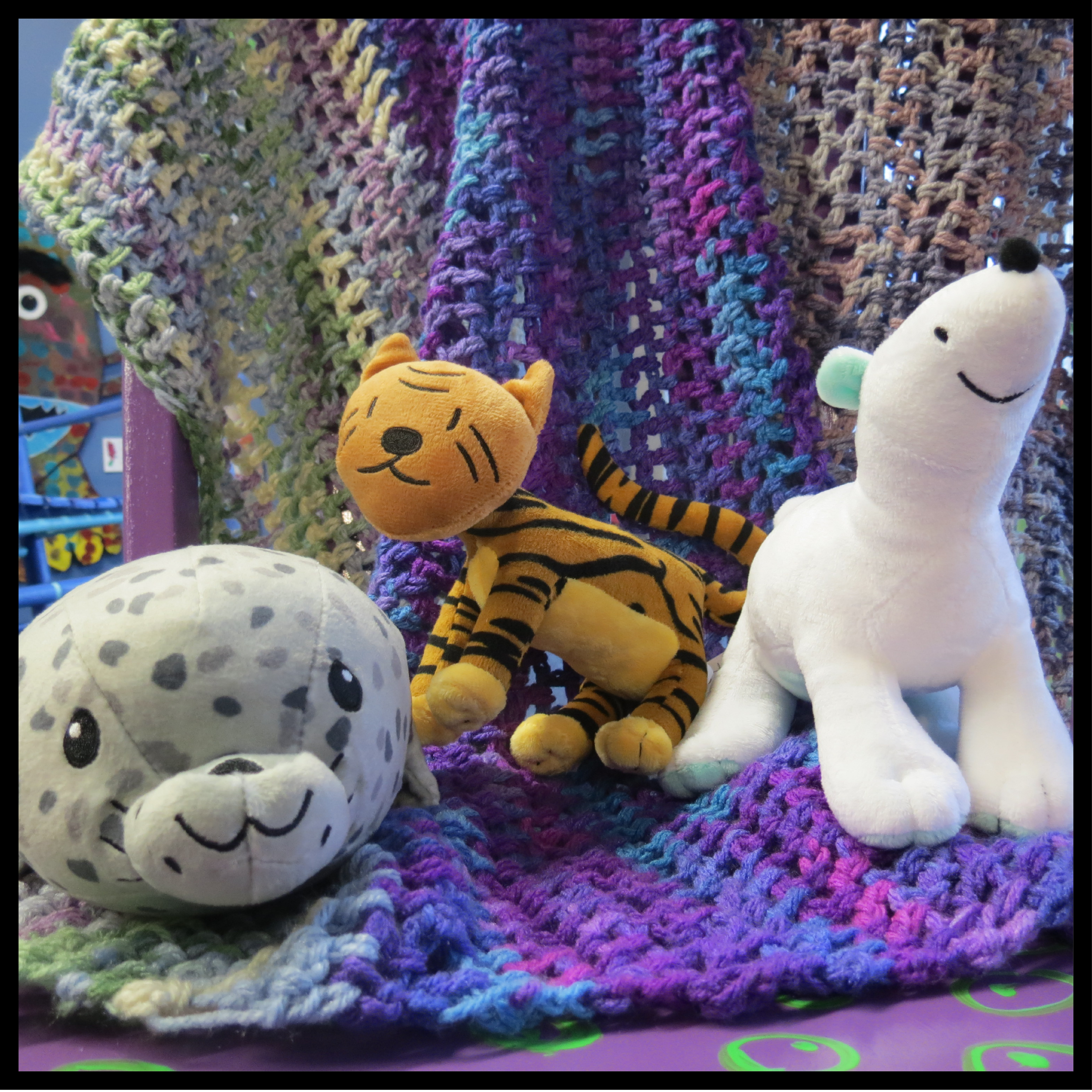 Three stuffed zoo animals, including a seal, tiger, and polar bear.
