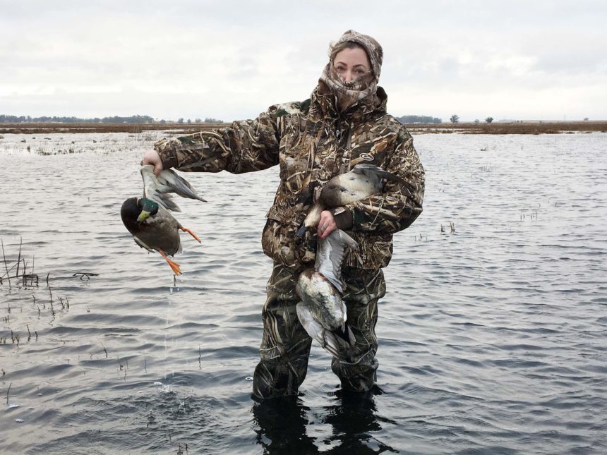 A hunter retrieves ducks