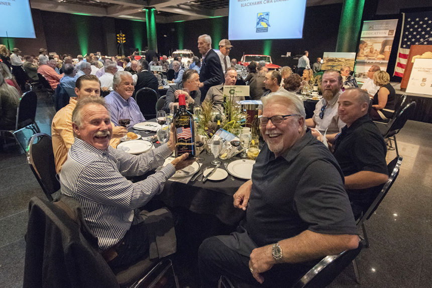 Participants at California Waterfowl's Blackhawk fundraising dinner grin at the camera