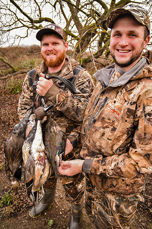 Two hunters pose after a hunt with California Waterfowl.
