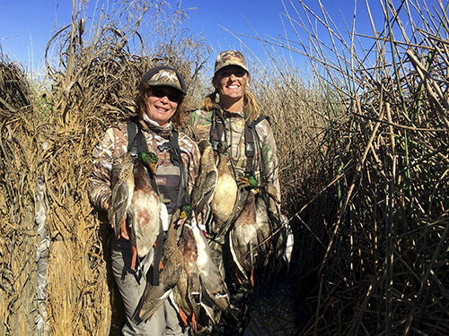 Two women smile after a hunt with California Waterfowl.