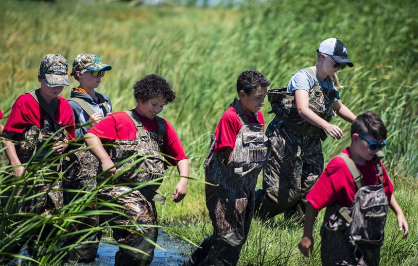 CWA campers walk through wetlands at hunter conservation camp.