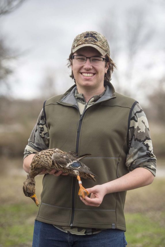 A youth hunter holds a banded hen mallard 