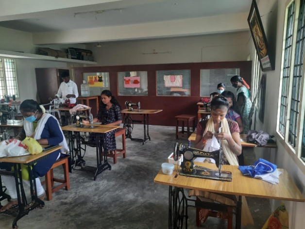 Women learning tailoring at sewing machines