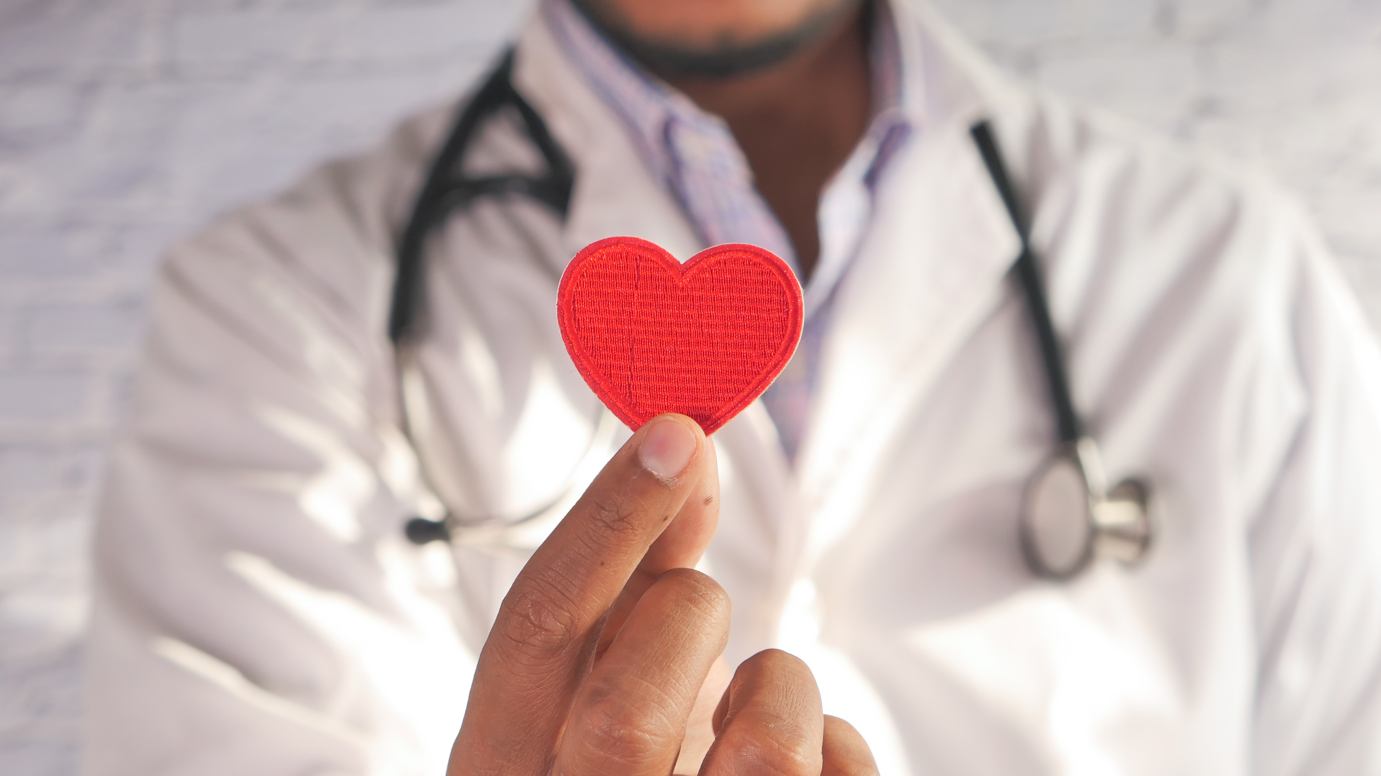 Doctor holding a cardboard red heart