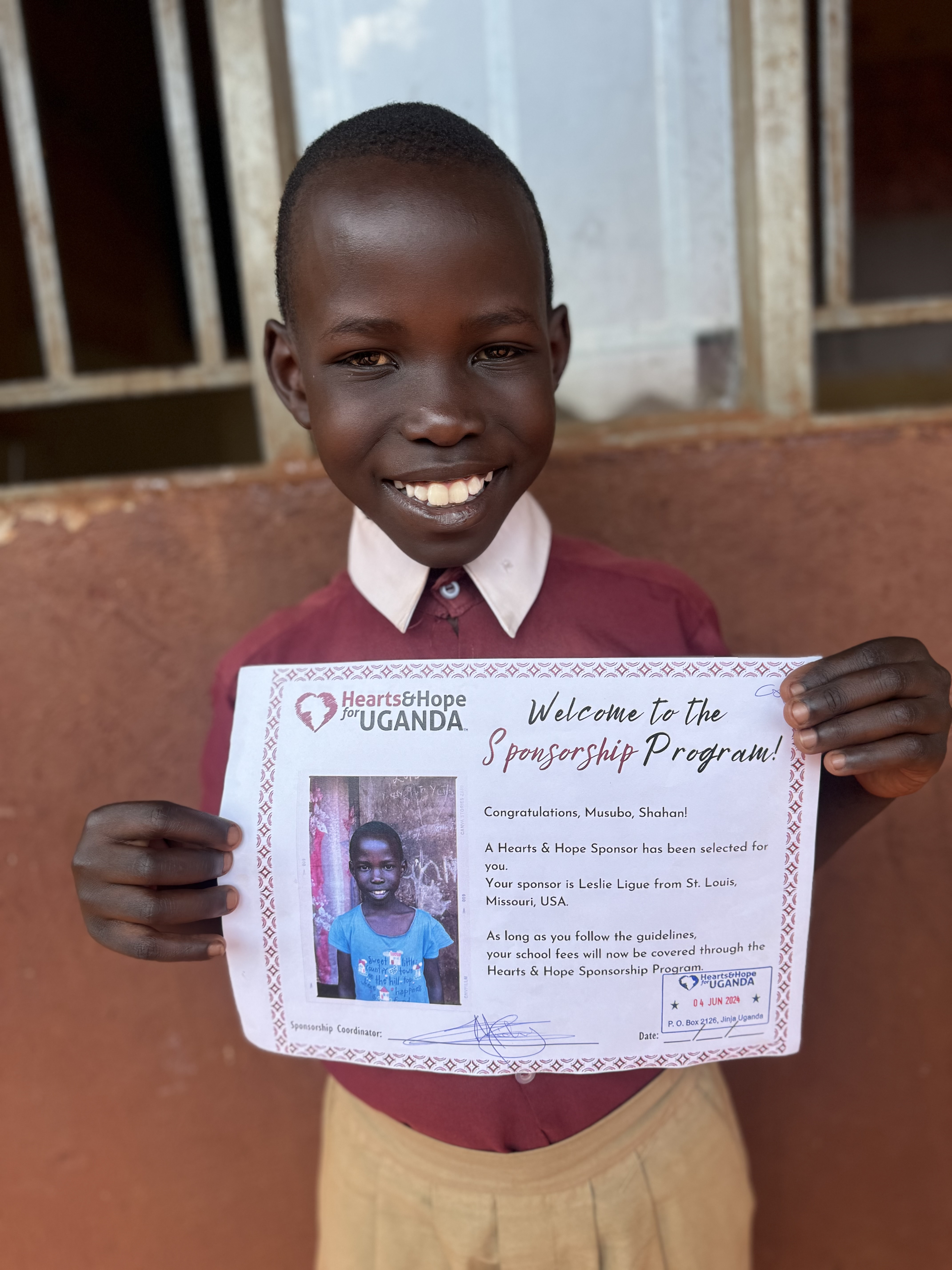 child holding their sponsorship certificate