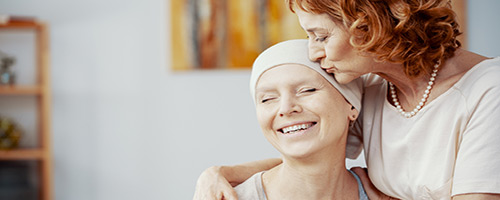 Daughter kissing mother on head.