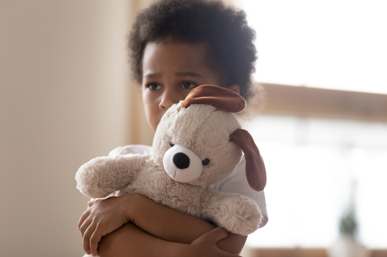 Sad young boy with stuffed animal