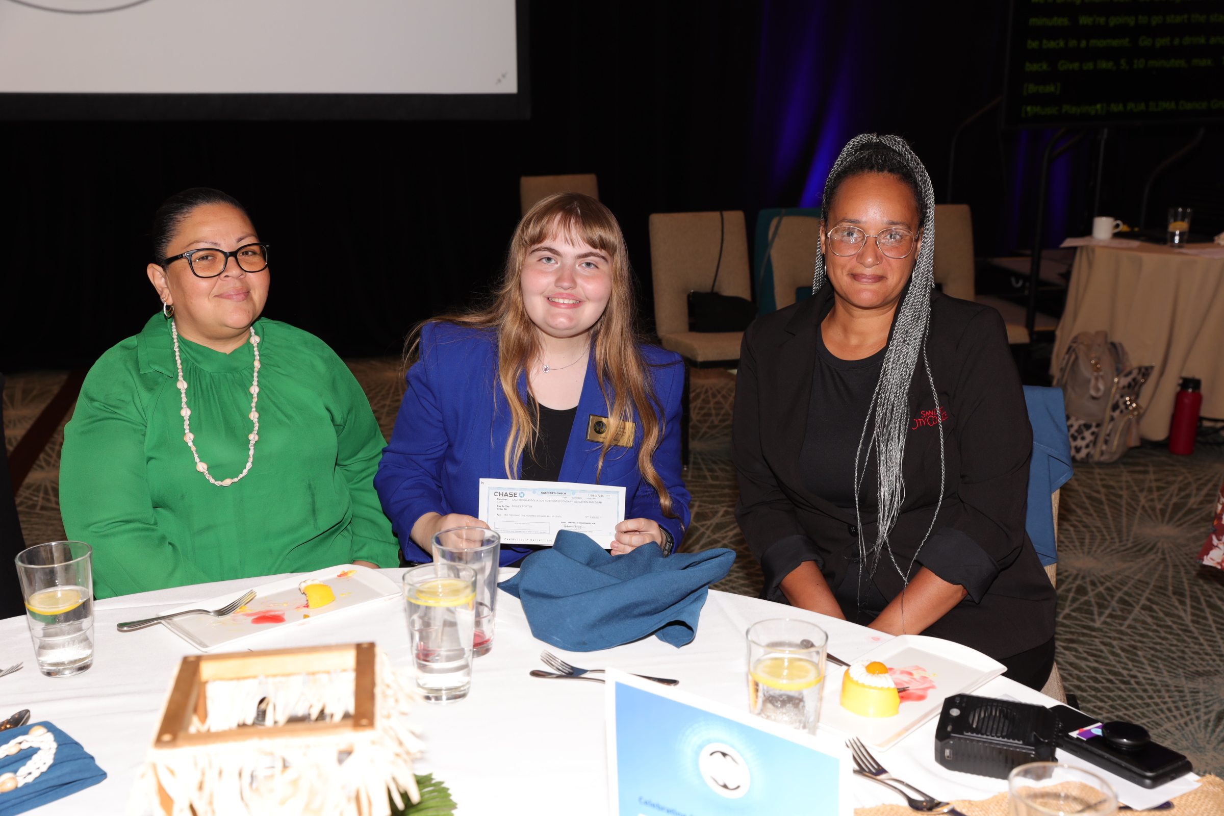 Three CAPED scholarship winners sitting together at President's Reception