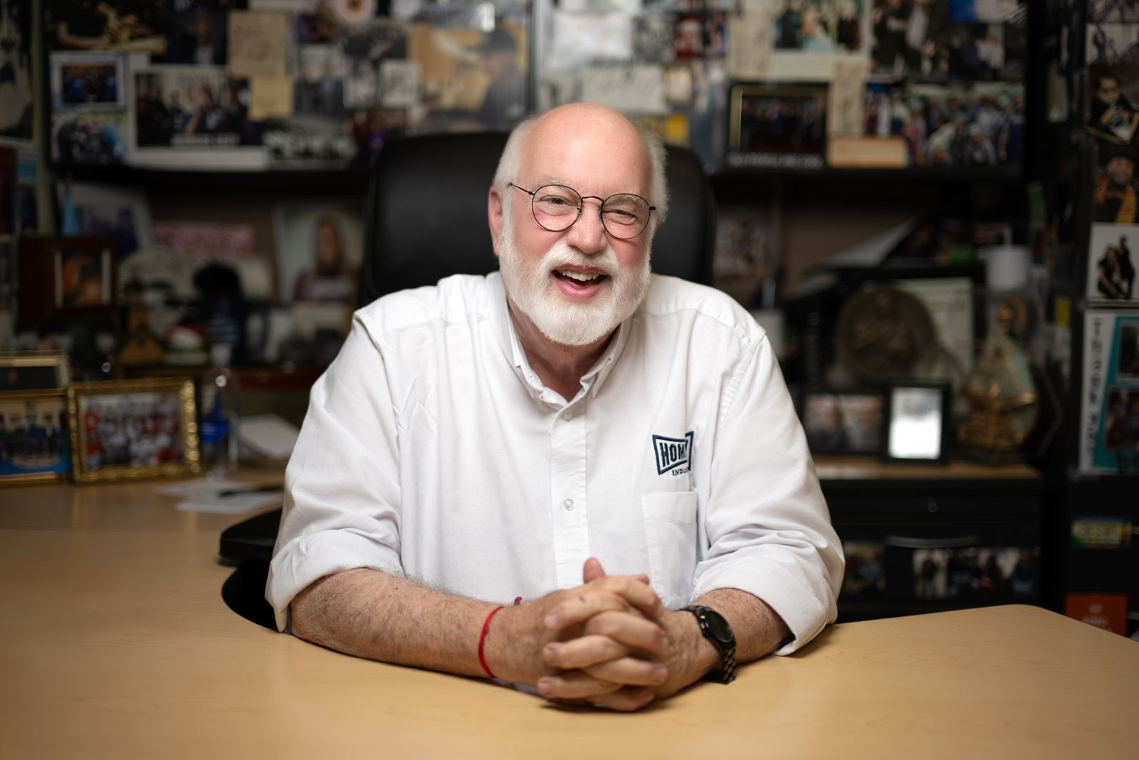 Father Boyle sitting at a desk smiling